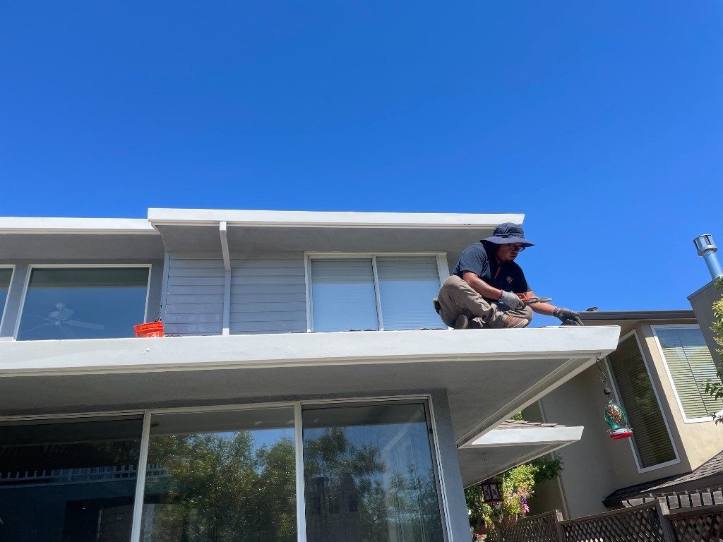 Technician working on gutter guard installation from the rooftop