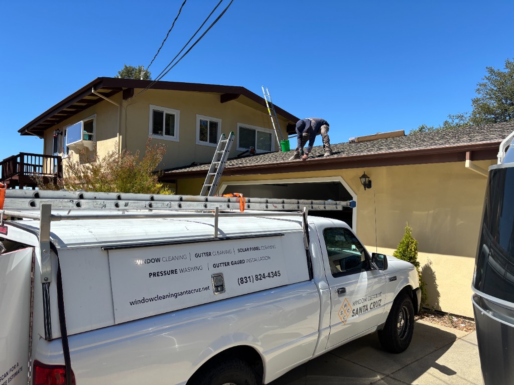 Window Cleaning Santa Cruz branded truck with technician installing gutter guards on roof